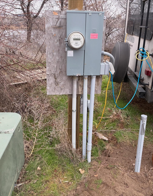 An outdoor electrical meter box with conduits installed on a wooden post by Tier 1 Electric in Boise, ID.