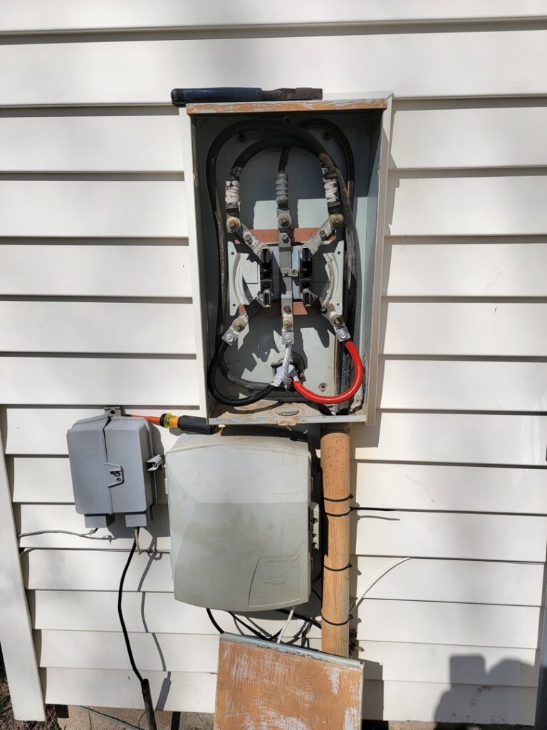 An outdoor electrical meter box with exposed wiring, indicating service or repair by Neptune Electric in Virginia Beach, VA.