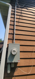 A newly installed outdoor electrical meter and conduit on a house by John Kivel Electric, LLC in Woodbury, MN.