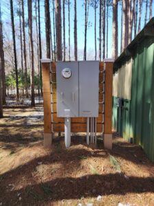 Outdoor electrical meter and service panel installed on a custom wooden structure by Apparent Electric LLC in Oshkosh, WI.