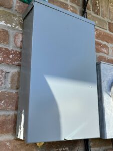 An outdoor electrical meter panel box installed on a brick wall by Solution Electric in Houston, TX.