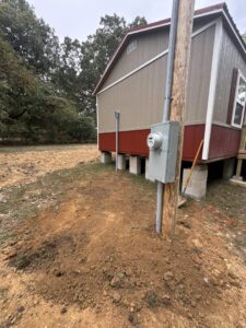 An outdoor electrical meter base and conduit installed on a wooden pole by Delta Current Electric in Jonesboro, AR.
