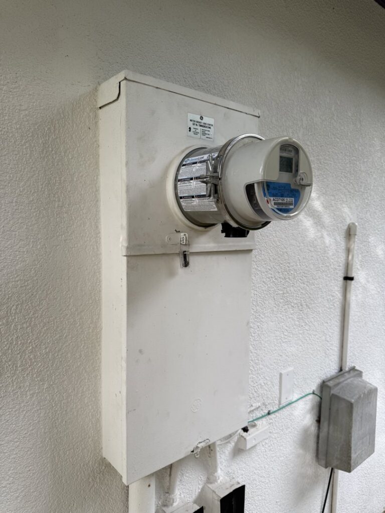 An outdoor electrical meter and service box on a residential building by Tenax Electrical Company in Jacksonville, FL.