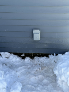 An outdoor electrical outlet installed on the side of a house by Bat Juice Electric LLC in Manchester, NH