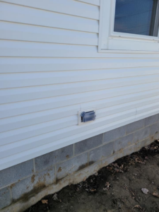 An outdoor electrical outlet with a protective cover installed on the exterior siding of a house by Benson Electric LLC in Owensboro, KY.
