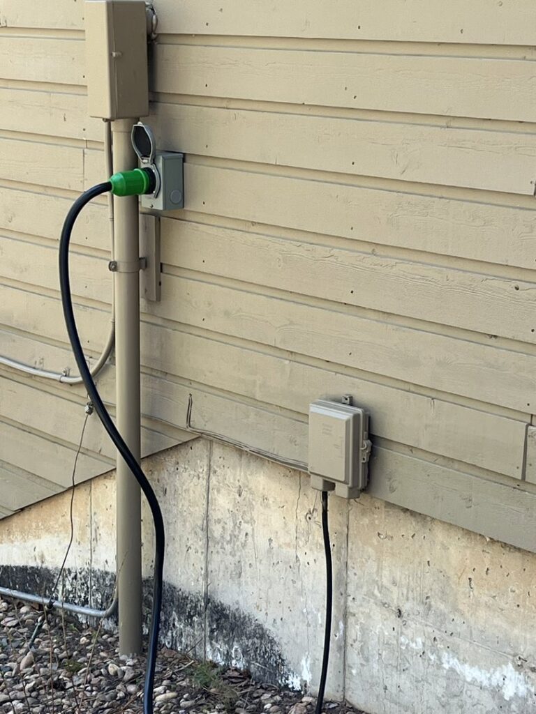 An outdoor electrical outlet and conduit installation on a building exterior by Mountain Electric in Knoxville, TN.