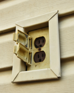 A close-up of an outdoor electrical outlet, ready for repair or replacement by coastline.electric.inc in Boston, MA.