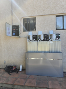 An outdoor electrical panel and Enphase battery storage system installation with tools by Ride the Lightning Electrical Services in El Cajon, CA.