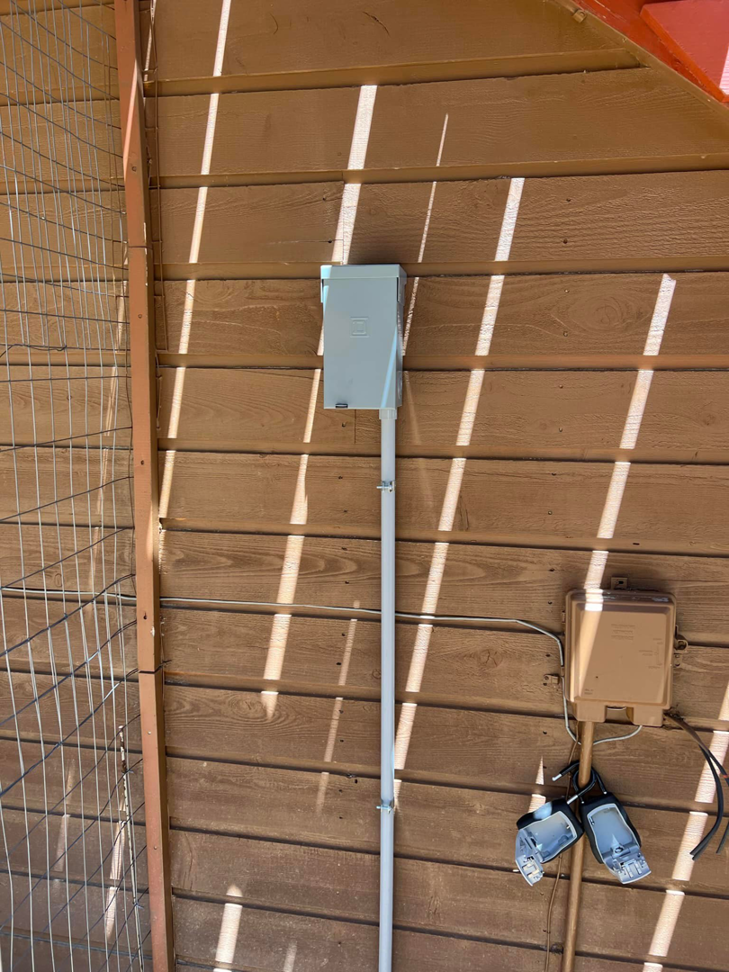 An outdoor electrical panel and conduit installation on a wooden exterior wall by P&E Electric in Denver, CO.