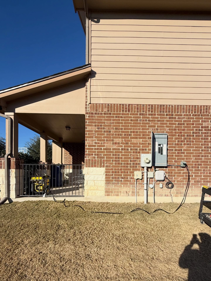Outdoor electrical panel and generator setup on a residential property by Powered By Voltron in San Antonio, TX.