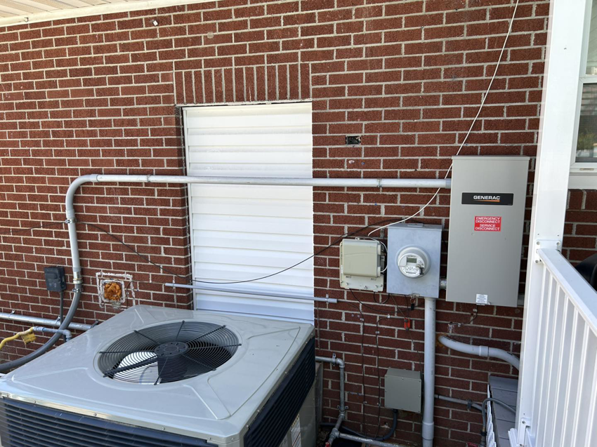 An outdoor electrical panel and Generac generator transfer switch installed by Parks Electric & Mechanical Co. in Newport News, VA.