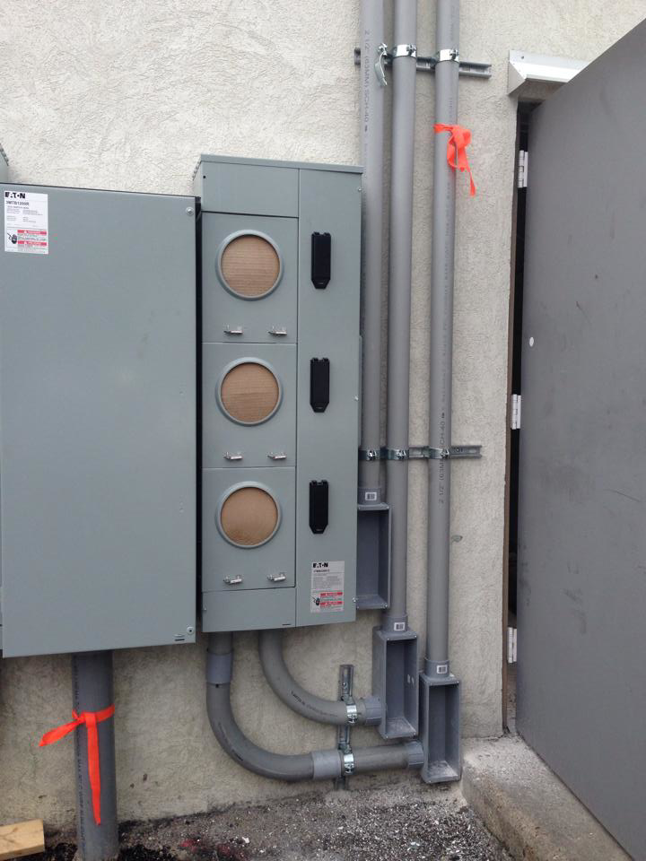 An outdoor electrical panel installation with conduits and meters by Bobby Burcher Electrical Inc. in Newport News, VA
