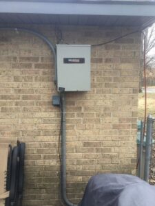 An outdoor electrical panel or generator transfer switch installed on a brick wall by Mr. Electric of Rogers in Rogers, AR.