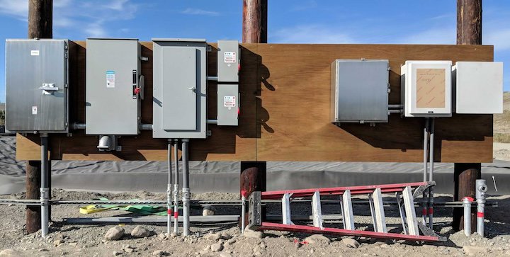 Outdoor electrical panels and conduits installed on a wooden structure, showcasing work by Premier Electric LLC in Palmer, AK.