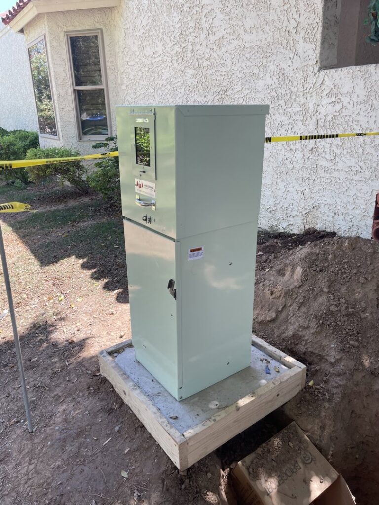 An outdoor electrical panel installation in progress by TAP and Sons Electric in Tempe, AZ, with caution tape.