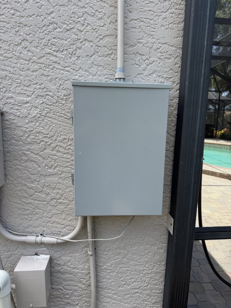 An outdoor electrical panel installed near a pool area by Dynamic Electric in Cape Coral, FL.