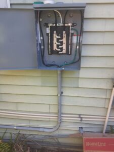 An outdoor electrical panel and conduit installed on the side of a residential building by Positricity in Clearwater, FL.