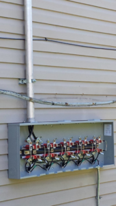 An outdoor electrical panel with wiring and components installed by Johns Electric Troubleshooting in Chicago, IL