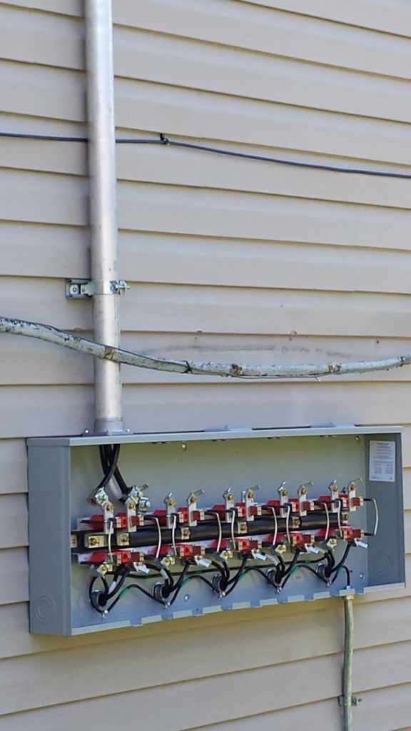 An outdoor electrical panel with wiring and components installed by Johns Electric Troubleshooting in Chicago, IL