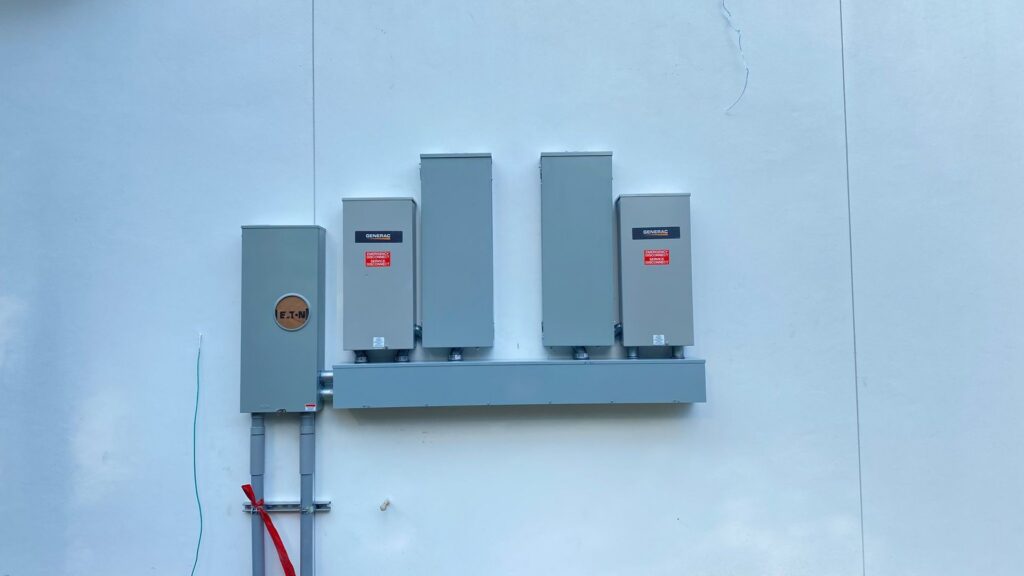 Multiple outdoor electrical panels, including Generac units, installed by Llanos Electric Builders in Houston, TX.