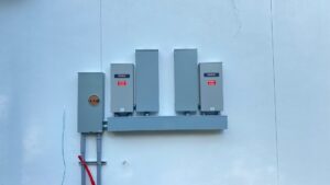 Multiple outdoor electrical panels, including Generac units, installed by Llanos Electric Builders in Houston, TX.