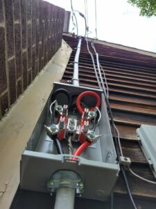 Outdoor electrical service entrance and conduit installed on the side of a residential building by Maiolo Electric in Pittsburgh, PA.