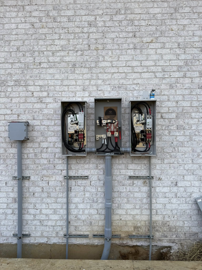 Outdoor electrical meter bases and conduit installed on a brick wall by Power House Electrical LLC in Johnson City, TN