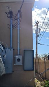 An outdoor electrical service entrance installation with conduits and meter base by V Electrical LLC in Albuquerque, NM.