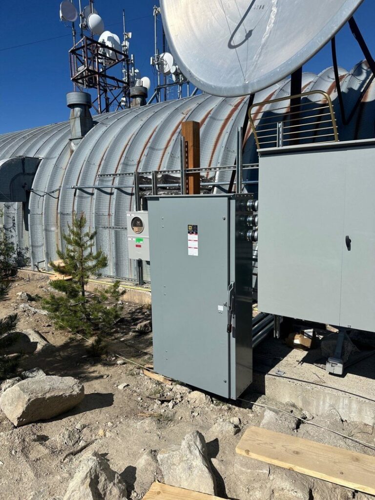 An outdoor electrical service panel and meter base installed next to a building by Trademark Elite Electrical Services in Butte, MT