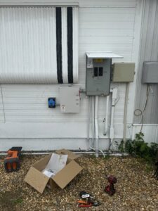 An outdoor electrical service upgrade and installation with multiple panels and tools by River Electric, LLC in Greenville, SC.