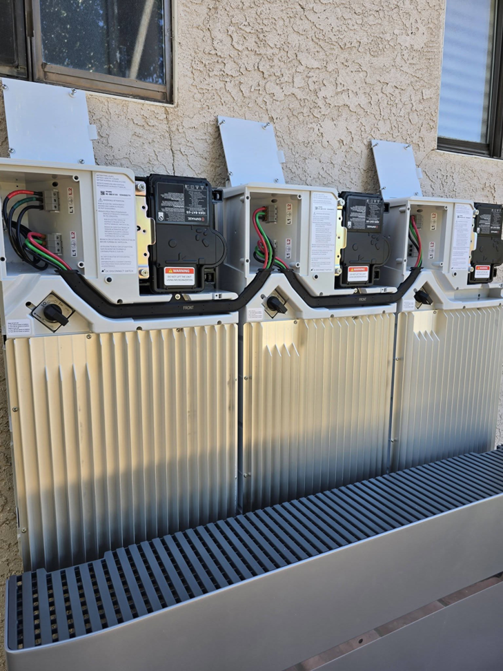 Outdoor electrical units, possibly solar inverters or battery storage, installed by Ride the Lightning Electrical Services in El Cajon, CA.