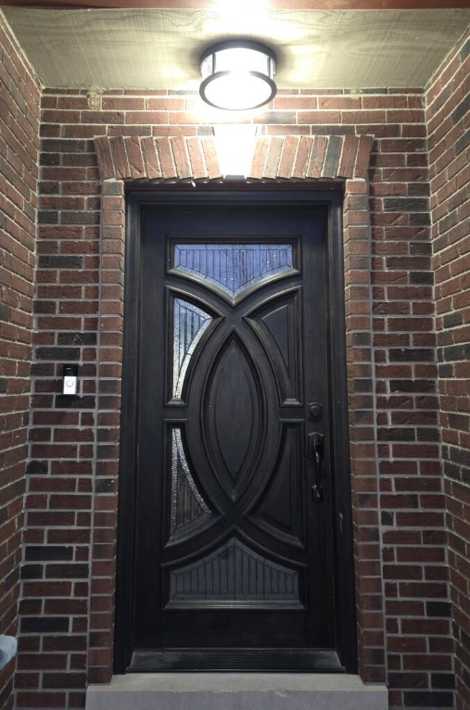 An outdoor light fixture and doorbell system installed above a front door by ILIC Electric in Chicago, IL.