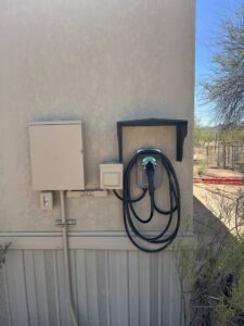 An outdoor EV charging station and electrical boxes installed on a home exterior by HomeRun Electric LLC in Arlington, TX