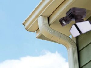 An outdoor floodlight installed under a gutter, a service offered by Decatur Electrician Now in Decatur, AL.