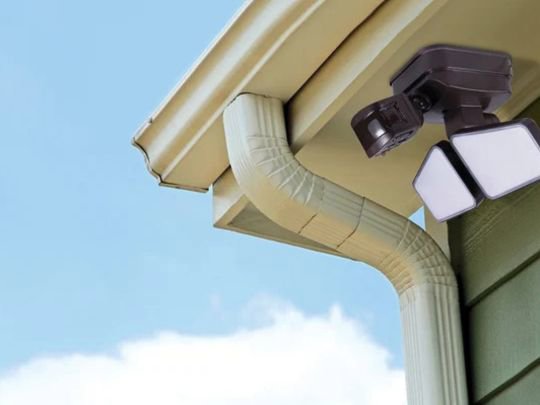 An outdoor floodlight installed under a gutter, a service offered by Decatur Electrician Now in Decatur, AL.