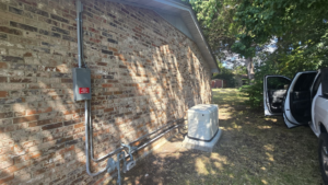 An outdoor generator and electrical conduit installation on a brick house by Mcgehee Electric, LLC in Montgomery, AL.