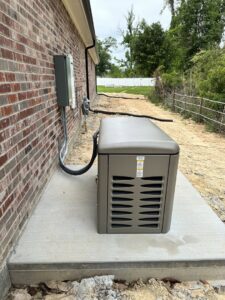 An outdoor standby generator installation with electrical connections on the side of a brick home by Babcock Electric & Communications in Lake Charles, LA.