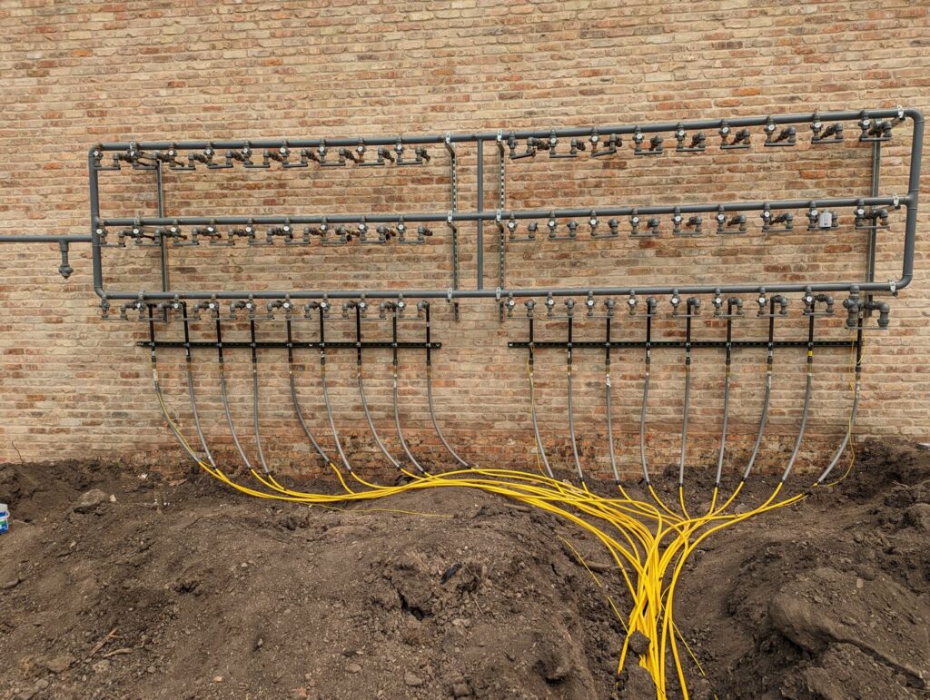 An outdoor geothermal or hydronic piping system installed by Advantage Mechanical, Inc. in Appleton, WI.