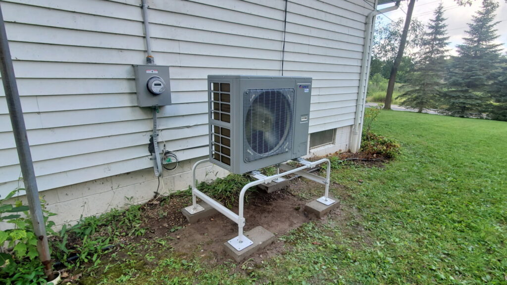 An outdoor heat pump or air conditioning unit installed next to a house by Empire Heating & Air Conditioning in Decatur, GA