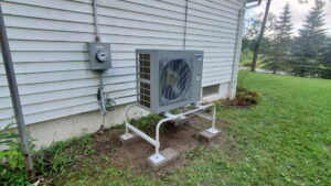 An outdoor heat pump or air conditioning unit installed next to a house by Empire Heating & Air Conditioning in Decatur, GA