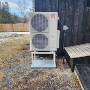 An outdoor heat pump or mini-split condenser unit installed by All The Way Heating & Cooling in Middleburgh, NY