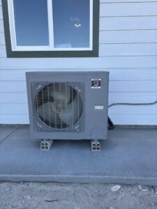 An outdoor heat pump condenser unit installed by Kingdom Heating and Air in Sacramento, CA.