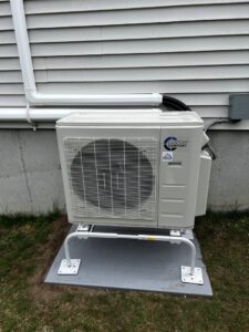 An outdoor heat pump unit professionally installed next to a residential building by A&D Ductless LLC in Lunenburg, MA.