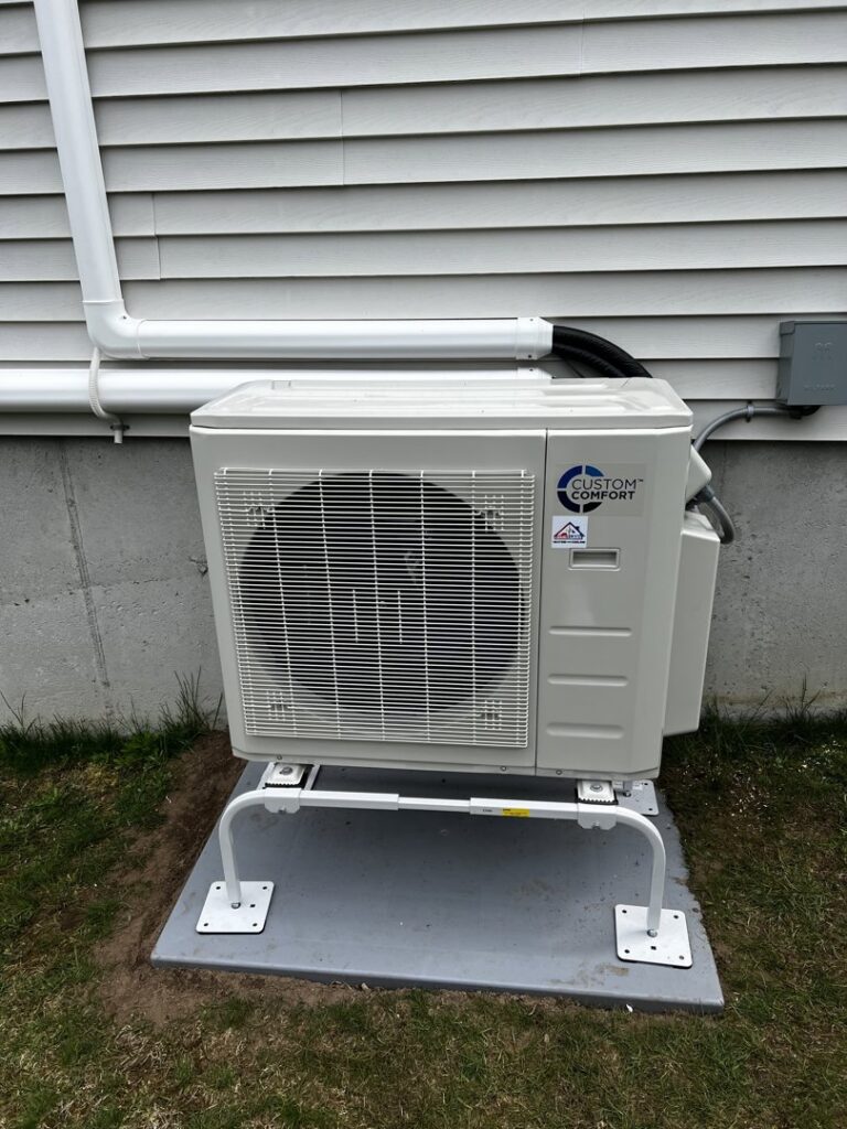 An outdoor heat pump unit professionally installed next to a residential building by A&D Ductless LLC in Lunenburg, MA.