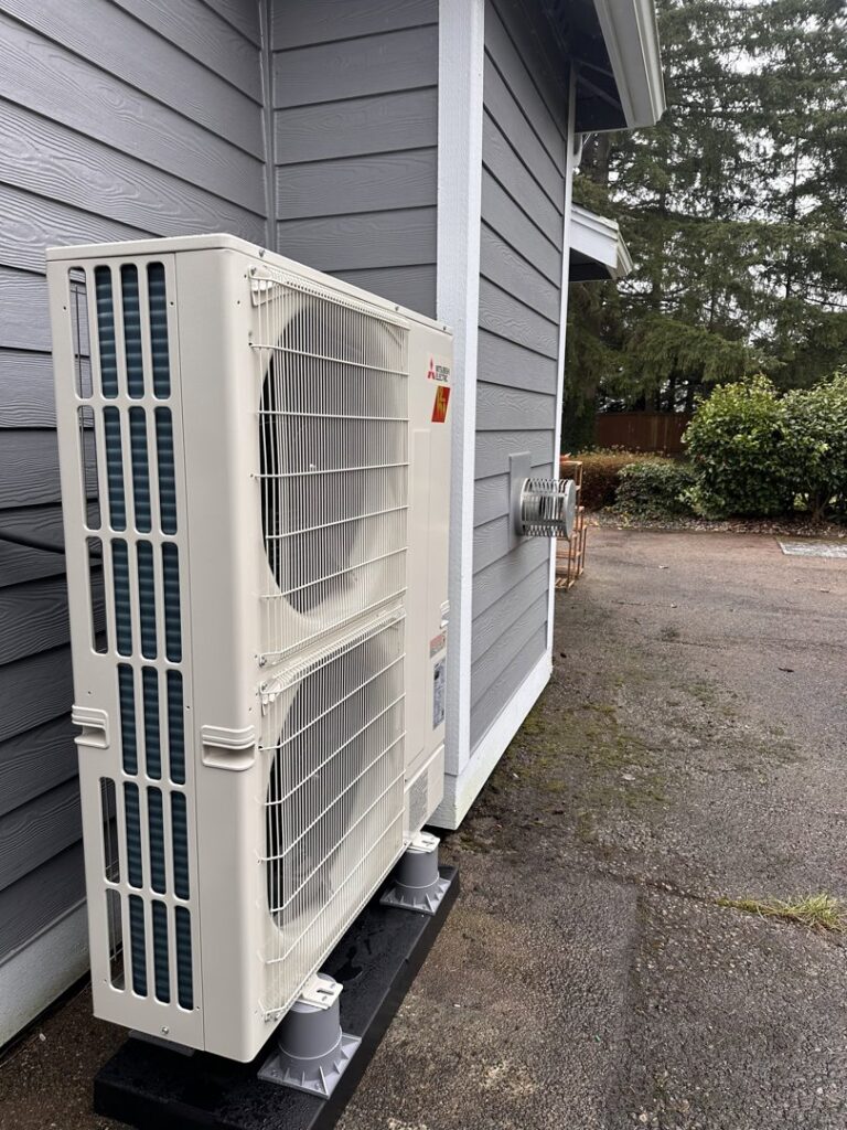 Newly installed outdoor heat pump unit next to a residential building by GreenFlow Heating & Cooling in Tacoma, WA