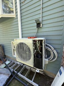 An outdoor heat pump condenser unit being installed or serviced by Massachusetts Pro HVAC in Shrewsbury, MA.