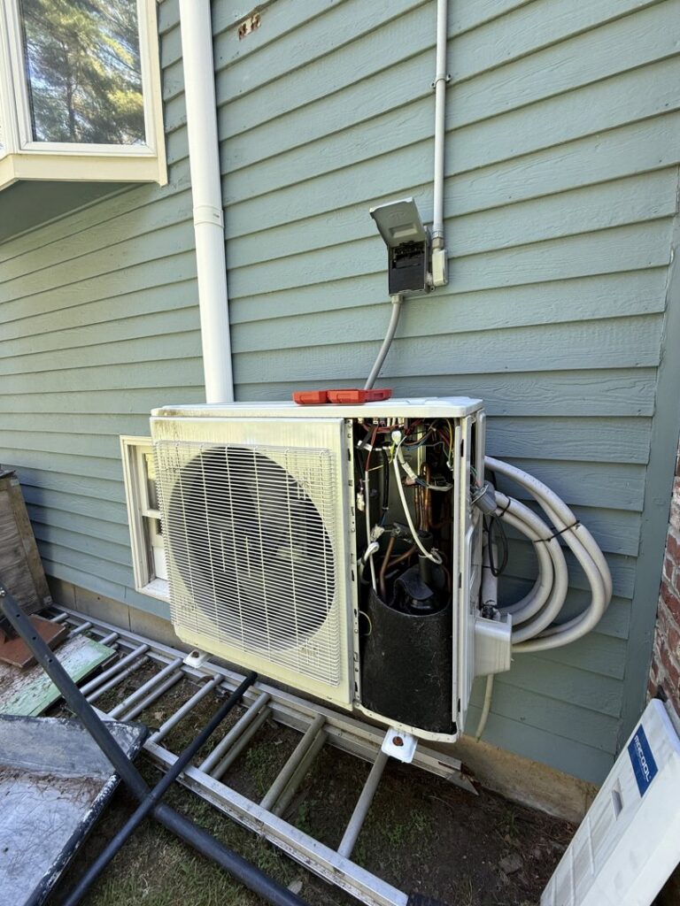 An outdoor heat pump condenser unit being installed or serviced by Massachusetts Pro HVAC in Shrewsbury, MA.