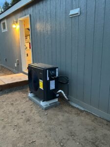 An outdoor heat pump unit recently installed next to a building by Semenik Hvac/r in Spokane, WA.