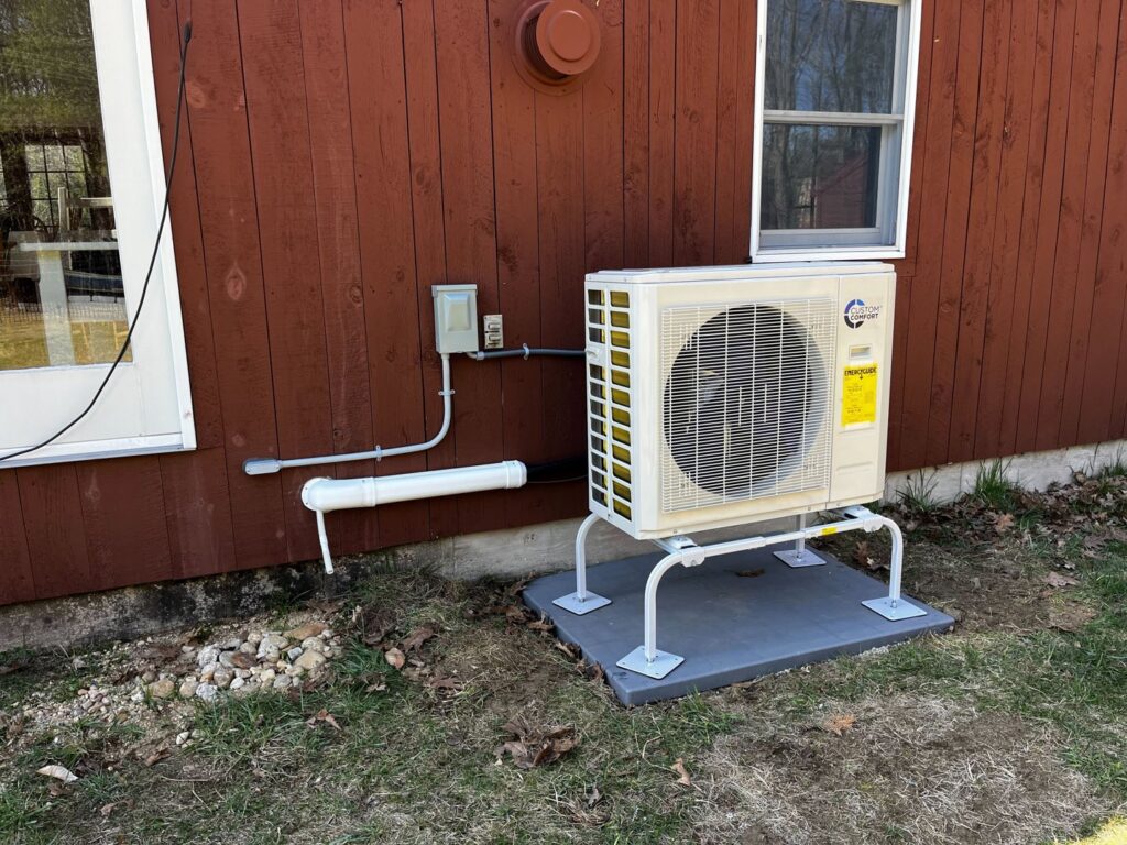 A newly installed outdoor heat pump system with visible piping next to a house, completed by A&D Ductless LLC in Lunenburg, MA.