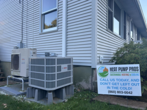 An outdoor Fujitsu and Bosch heat pump system installed by Heat Pump Pros next to a house in Hartford, CT.
